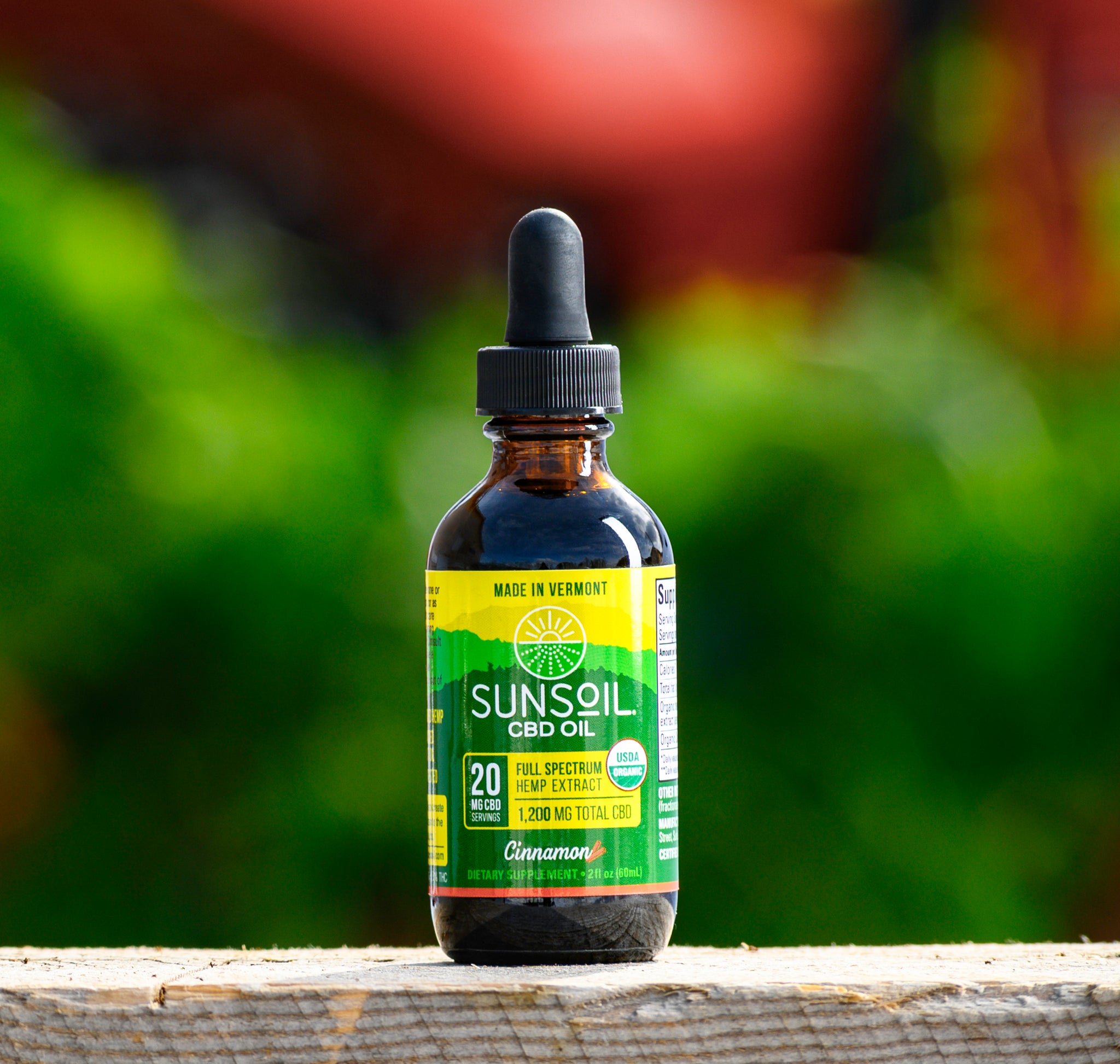 A dark glass bottle with Sunsoil's green and yellow label for the Cinnamon liquid CBD