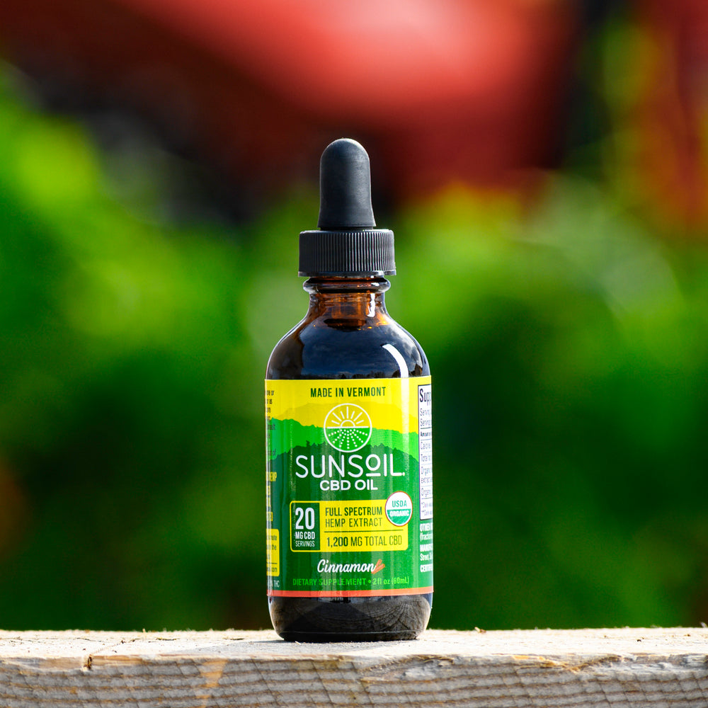 A dark glass bottle with Sunsoil's green and yellow label for the Cinnamon liquid CBD