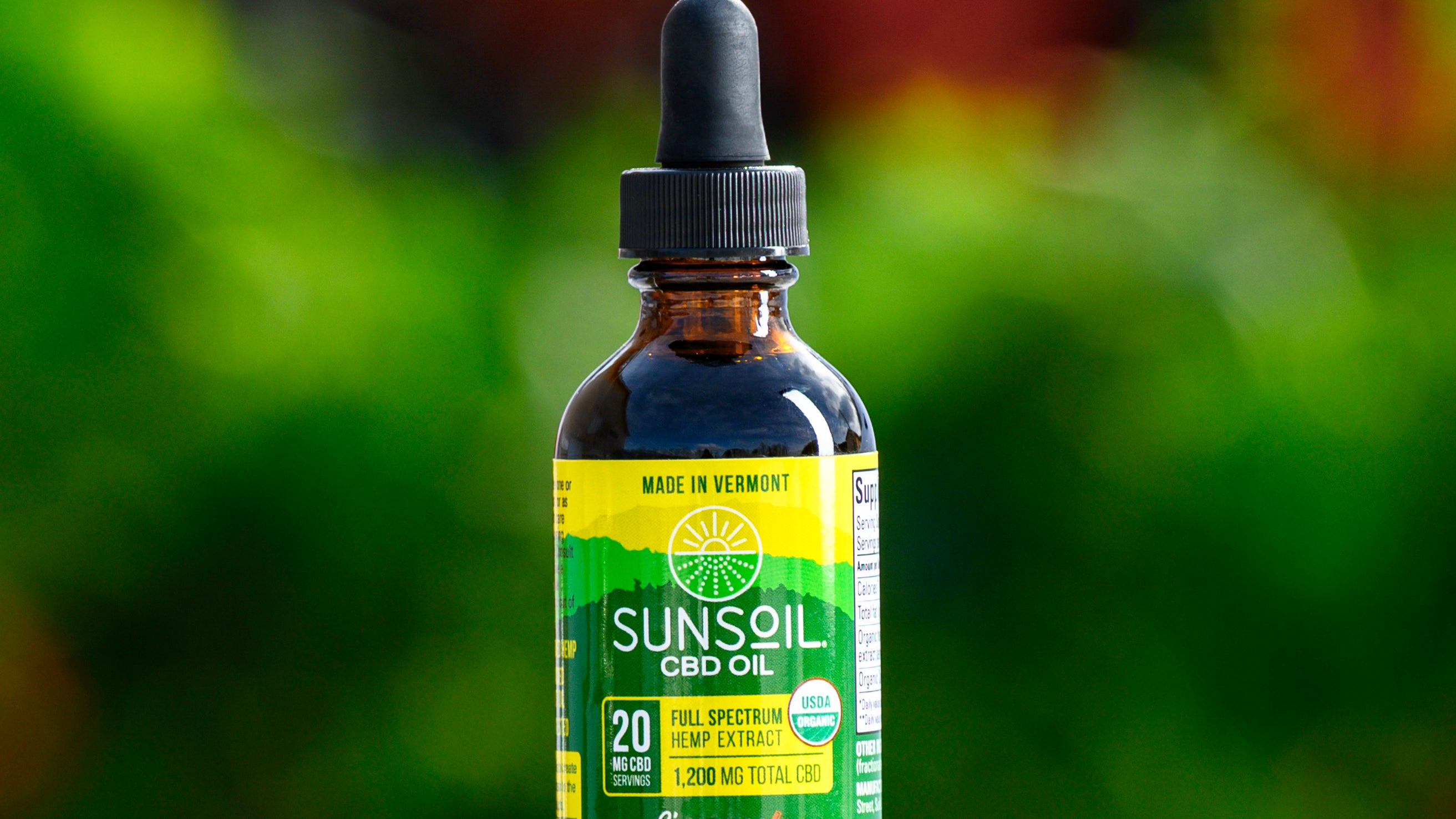 A dark glass bottle with Sunsoil's green and yellow label for the Cinnamon liquid CBD